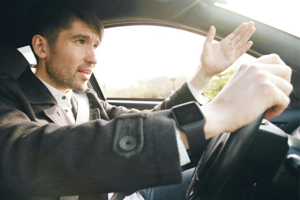 An irritated driver throwing his hands up