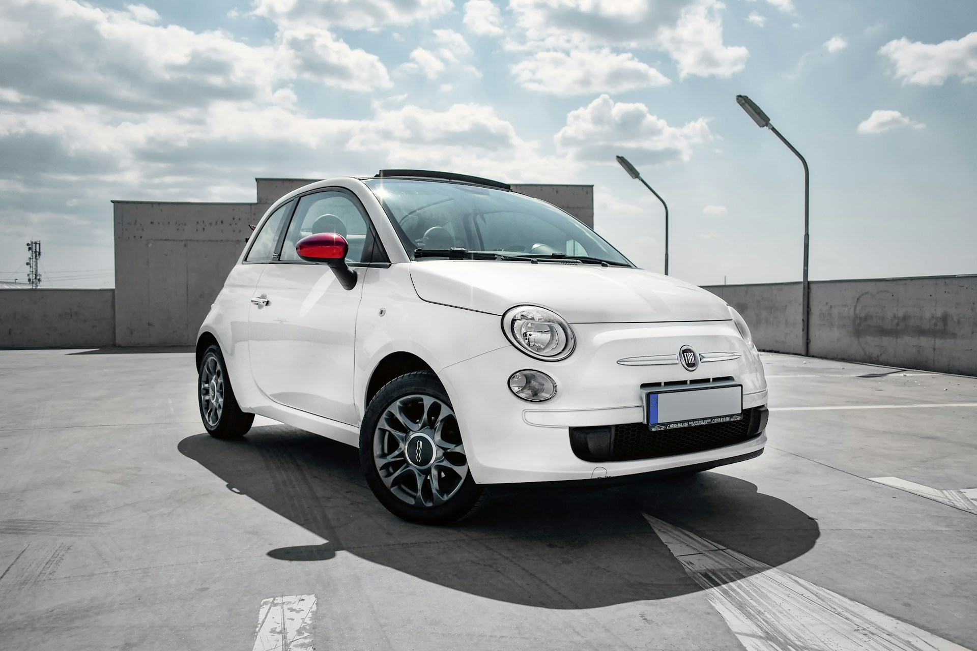 A white Fiat 500 in a car park