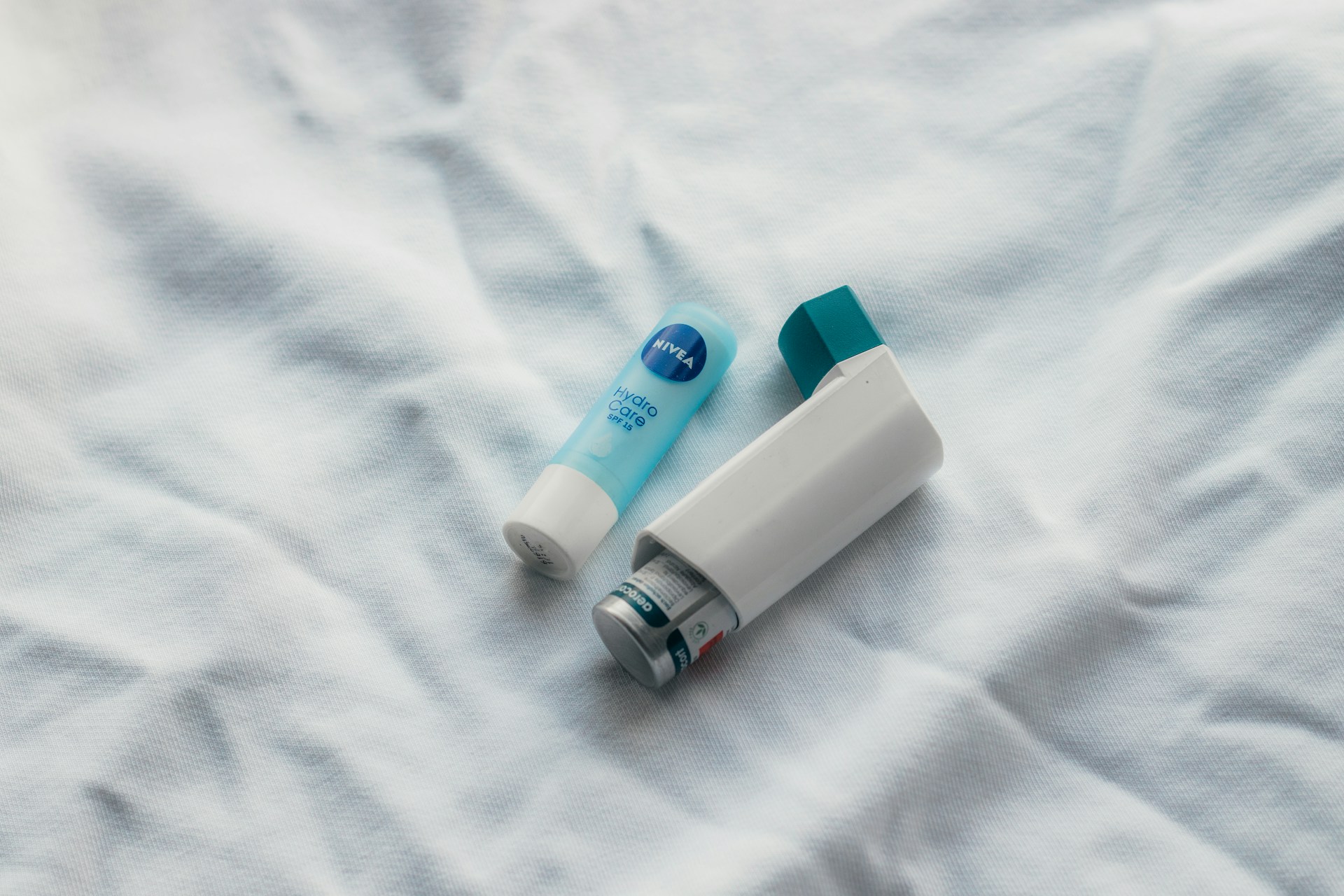 inhaler and small bottle on a white sheet