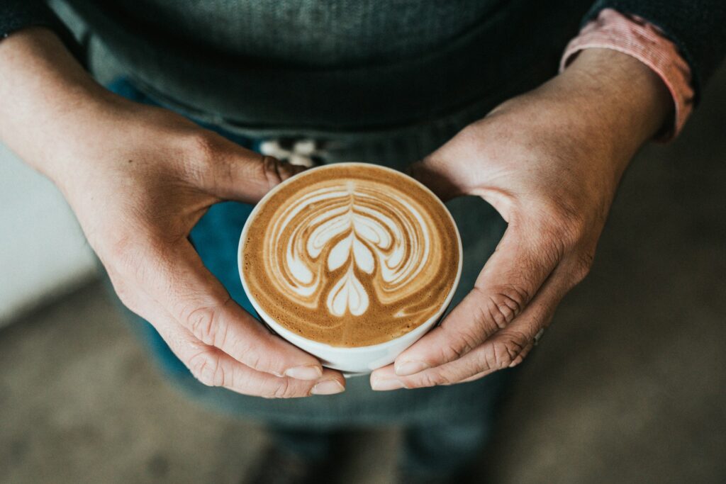 A person holding a large cup of coffee